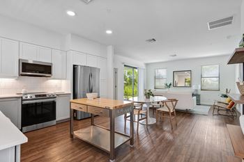 An open kitchen and dining room with a table and chairs